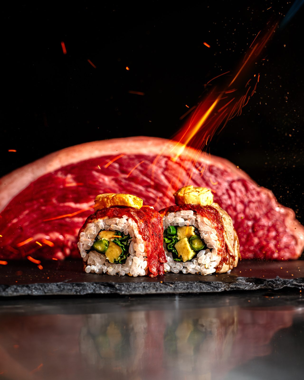 Uramaki El Blanquet flameado ante la vaca madurada, entre chispas — KNAYA Raw & Fire