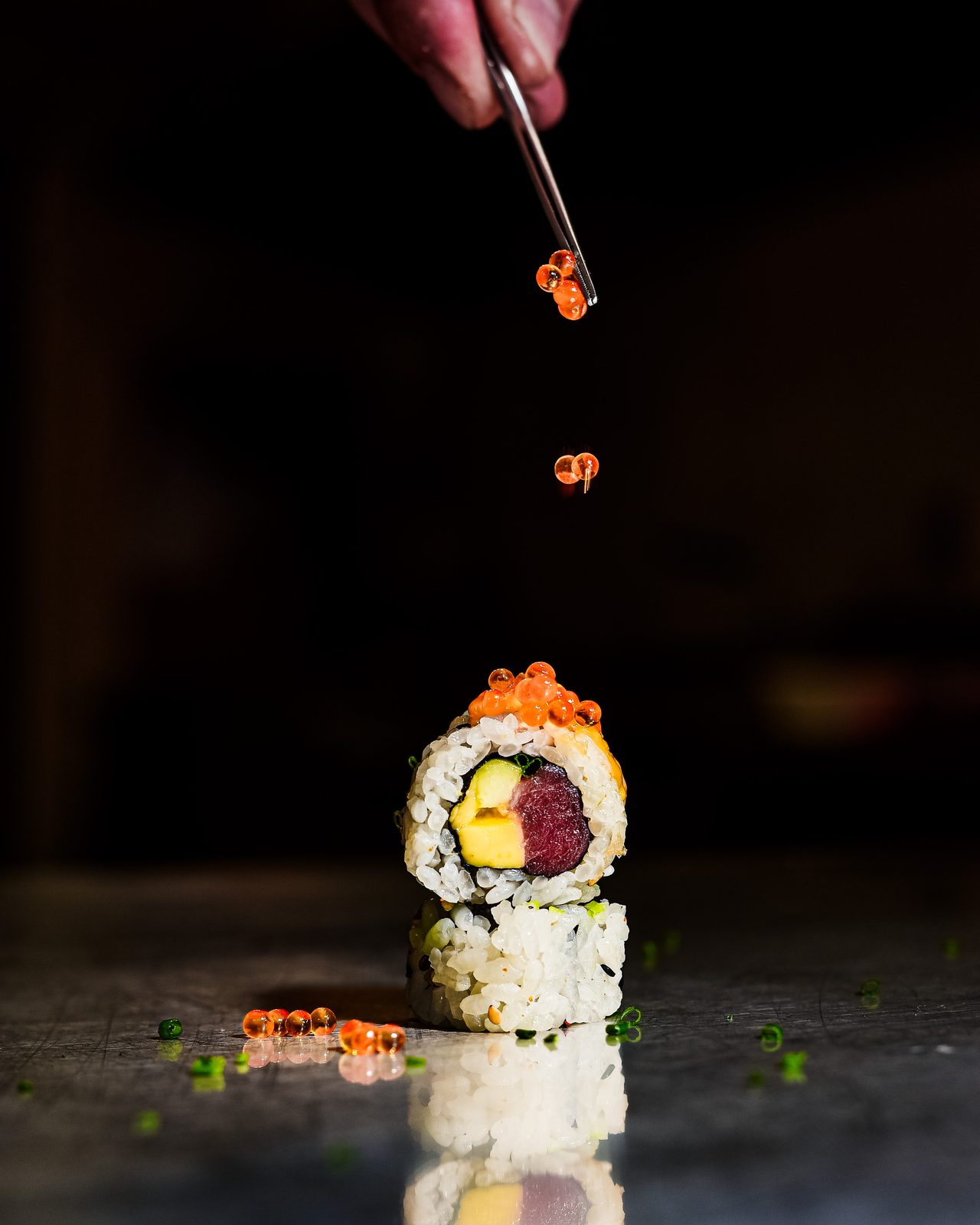 Uramaki de la terreta rematado con huevas, servido a pinza — KNAYA Raw & Fire